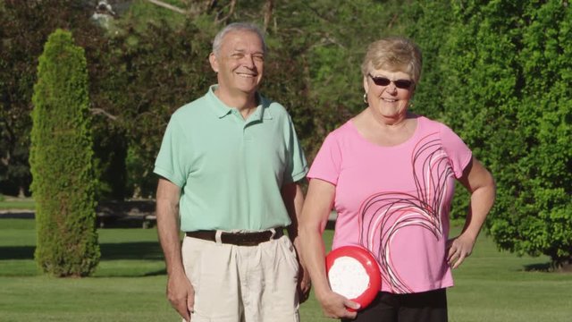 Elderly couple holding frisbee