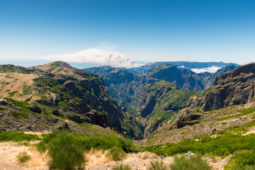Fototapeta na wymiar view from the pico do Arieiro on the Portuguese island of Madeira. In the background a forest fire