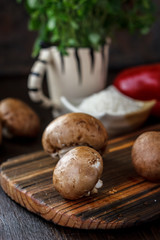 Raw mushrooms on wooden board. Three mushrooms on kitchen.