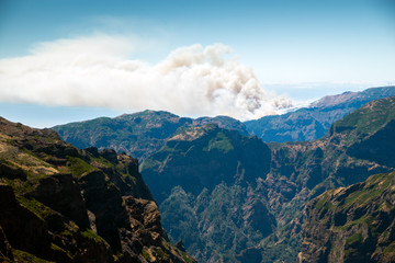 view from the pico do Arieiro on the Portuguese island of Madeira. In the background a forest fire
