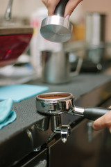 Fototapeta na wymiar Barista pulling coffee at metal holder for espresso making.