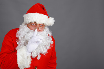 Real Santa Claus carrying big bag full of gifts, isolated on white background
