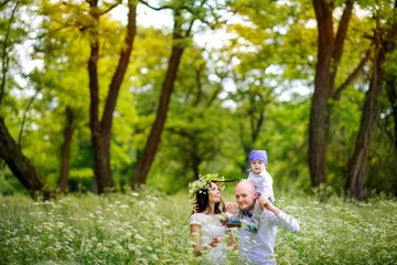 Fototapeta premium happy family walks in the evening park, everyone is smiling together