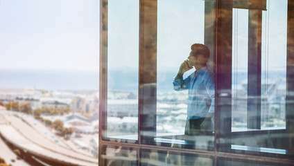 Businessman inside office building talking on mobile phone