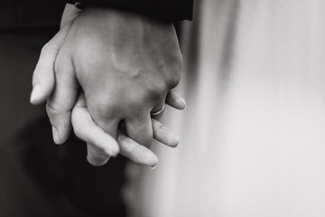 Bride and groom interlacing fingers black and white