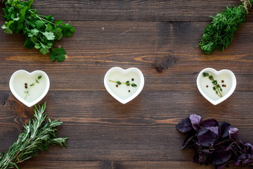 greenery with natural oil for cooking on wooden kitchen table background top view