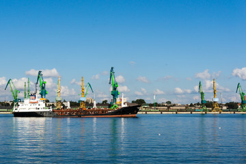Fototapeta premium Loading cranes and ship at Baltic sea in sea Port, Klaipeda, Lithuania. Sunset