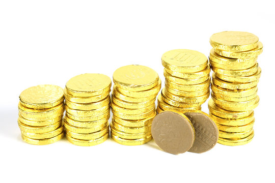 Stack of chocolate gold coins isolated on white background, golden wrapped