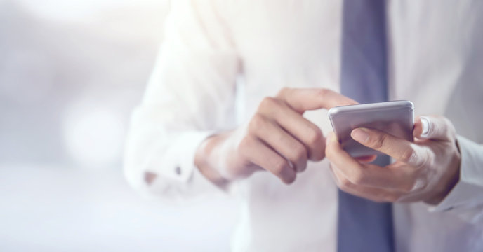 Close up of a business man using mobile smart phone, copy space.