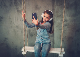 Little girl taking selfie on a swings