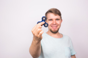 young man playing with a fidget spinner, focus on spinner.