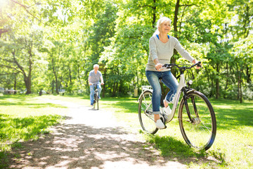 Senior Couple Riding Bikes In Park

