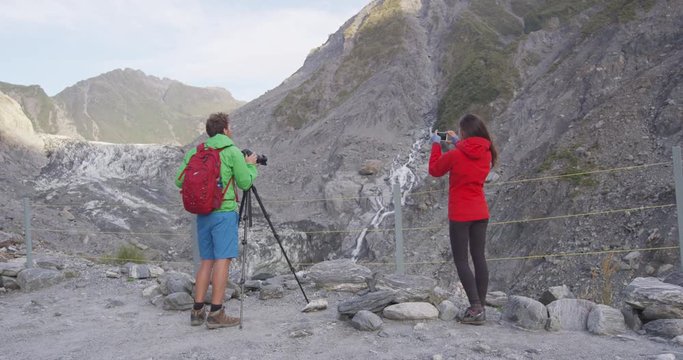 Tourists taking photos at Franz Josef Glacier in New Zealand. People looking at beautiful New Zealand nature landscape from viewpoint. RED EPIC SLOW MOTION.