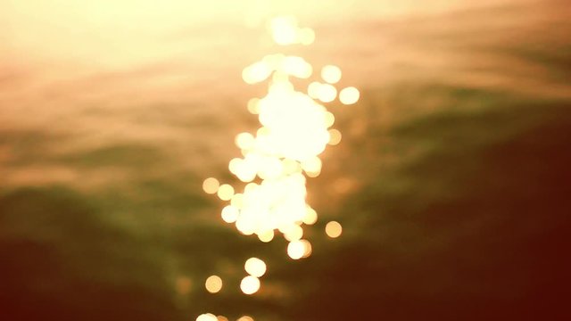 Glistening and shimmering ocean surface at sunset or twilight. Beautiful bokeh of dancing sun reflections on water in slow motion. hd, 1920x1080