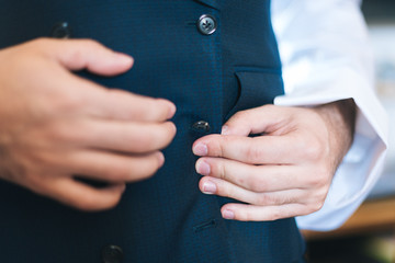 Man buttoning up his vest