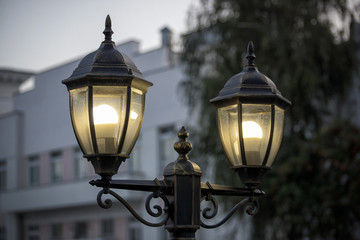 Fototapeta na wymiar Black street lamp against a blue evening sky.