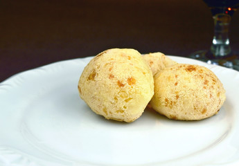 Brazilian typical food: Cheese Bread on a white plate isolated on black background