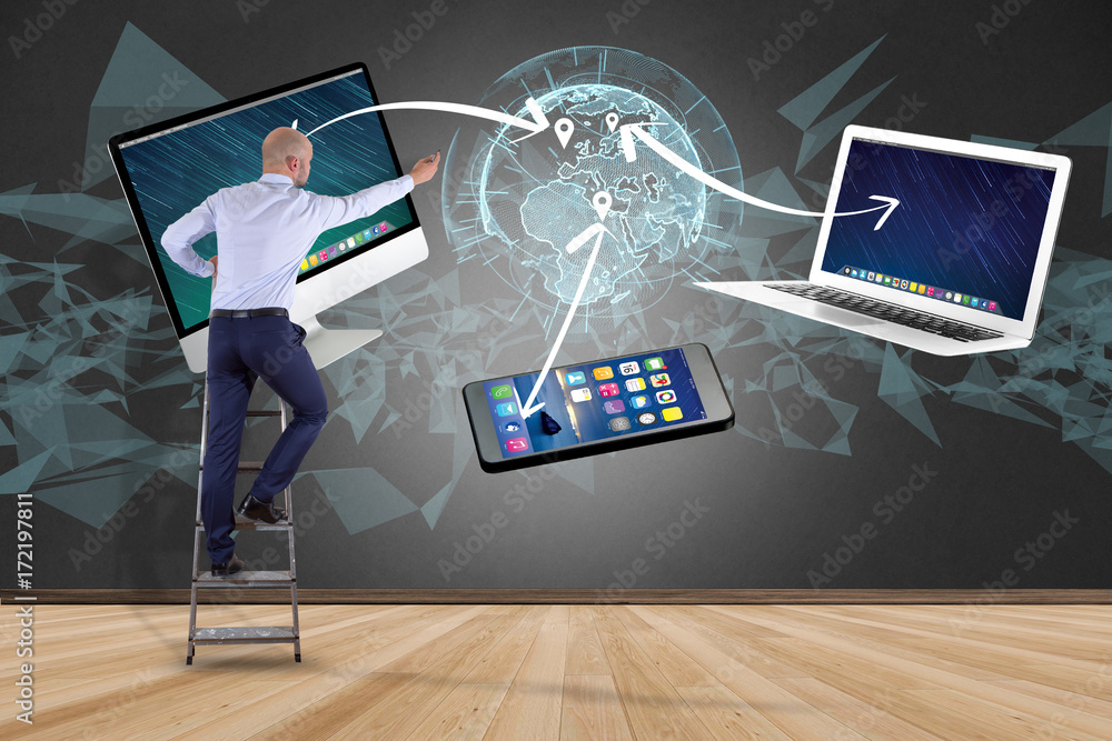 Poster businessman in front of a wall with computer and devices displayed on a futuristic interface with in