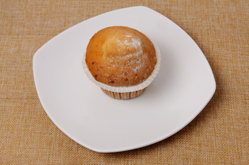 A fragrant appetizing cupcake on a white plate
