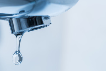 Tap and water drop close up