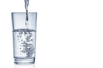 Flowing pure water into tumbler on white background