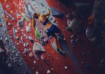 Female climber. Extreme indoor climbing.