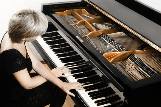 Piano player. Pianist woman playing grand piano