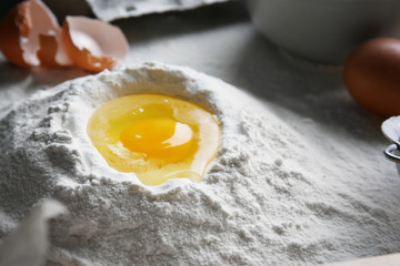 Flour and raw egg on kitchen table