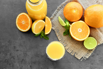 Bottle and glass with fresh orange juice on table