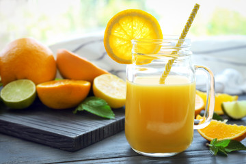 Fototapeta na wymiar Mason jar of fresh orange juice on table