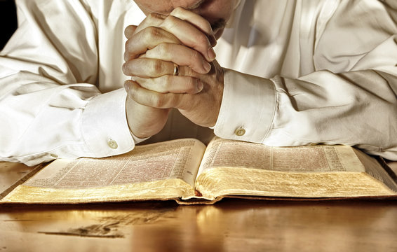 Man in Deep Prayer Over His Holy Bible