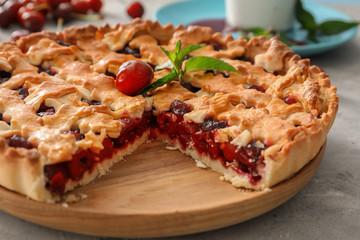 Sliced delicious cherry pie on wooden board