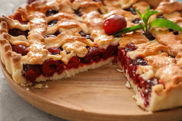 Sliced delicious cherry pie on wooden board
