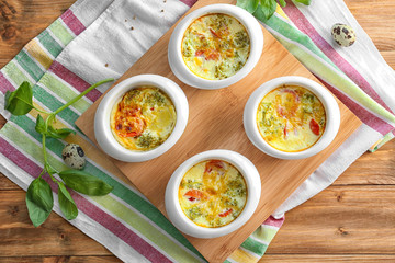 Ramekins with broccoli casserole on wooden stand