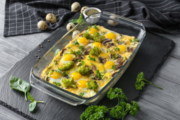 Baking dish with broccoli casserole on table