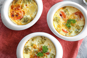 Ramekins with tasty broccoli casserole on table