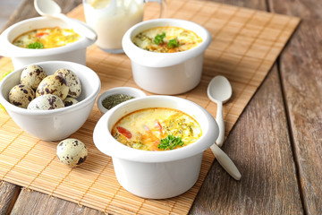 Ramekins with tasty broccoli casserole on wooden table