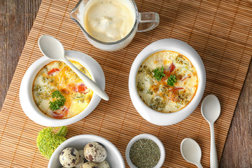 Ramekins with tasty broccoli casserole on wooden table