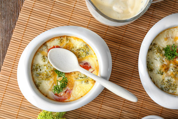 Ramekins with tasty broccoli casserole on table