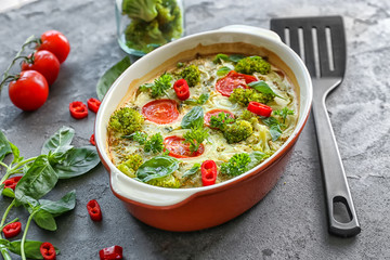 Baking dish with broccoli casserole on table