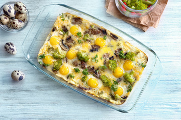 Baking dish with broccoli casserole on wooden table