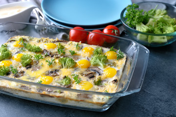 Baking dish with broccoli casserole on table