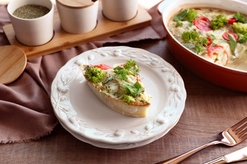 Plate with tasty broccoli casserole on table