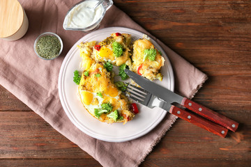 Plate with tasty broccoli casserole on wooden table