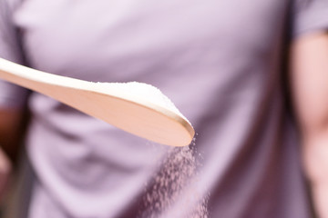 A man pours flour into a bowl. Cooking, baking.