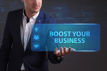Business, Technology, Internet and network concept. Young businessman working on a virtual screen of the future and sees the inscription: Boost your business