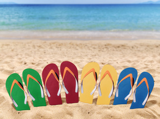 Fototapeta na wymiar Colorful Man lifestyle four relax flip flops in the sand with sea background