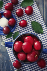 Ripe fresh plums in teapot on table