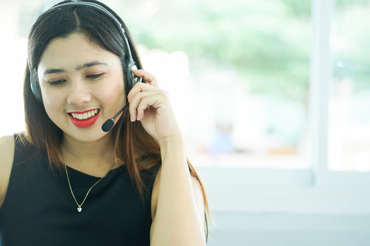 close up headphone asian help desk woman response answer customer or partner in operation room for business and technology concept.