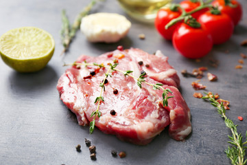 Fresh raw steak with thyme on table